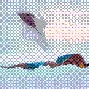 Superman lying down in the snow being jumped by the dog Krypto.